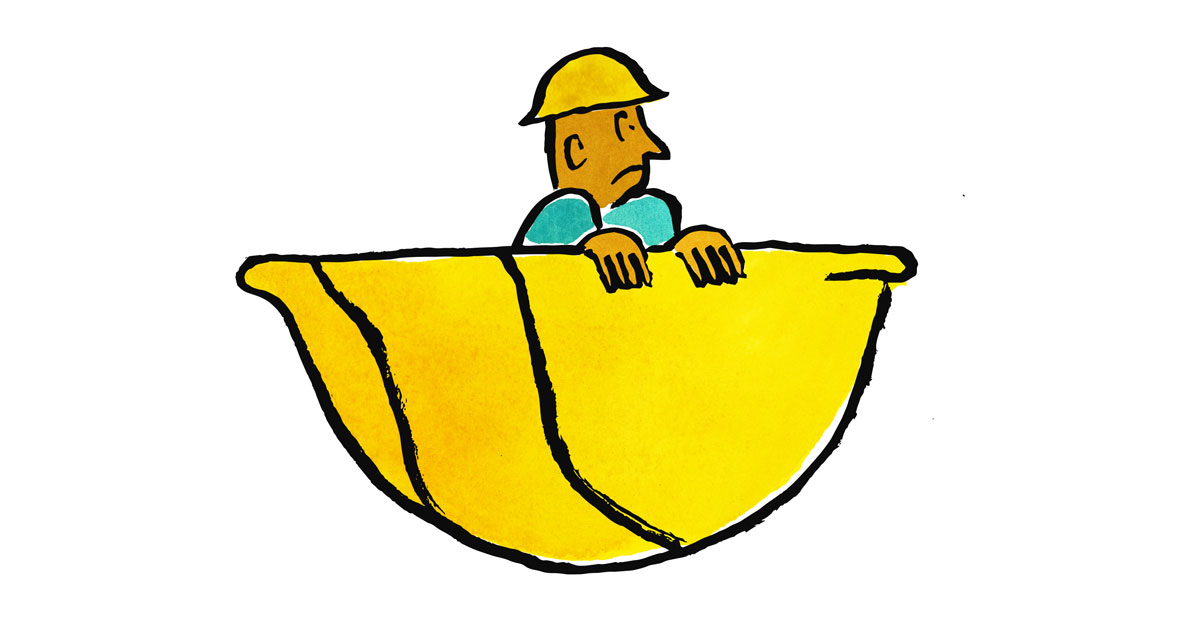 A worker sitting in a large hard hat