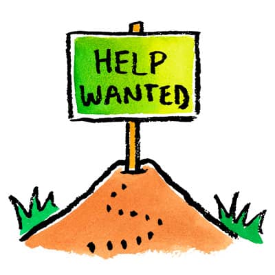 a help wanted sign on top of a mound of dirt